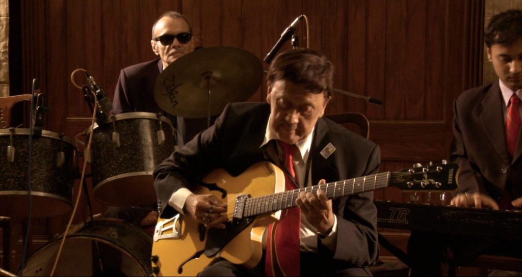 Carlton Kitto playing the guitar at one of his concerts.